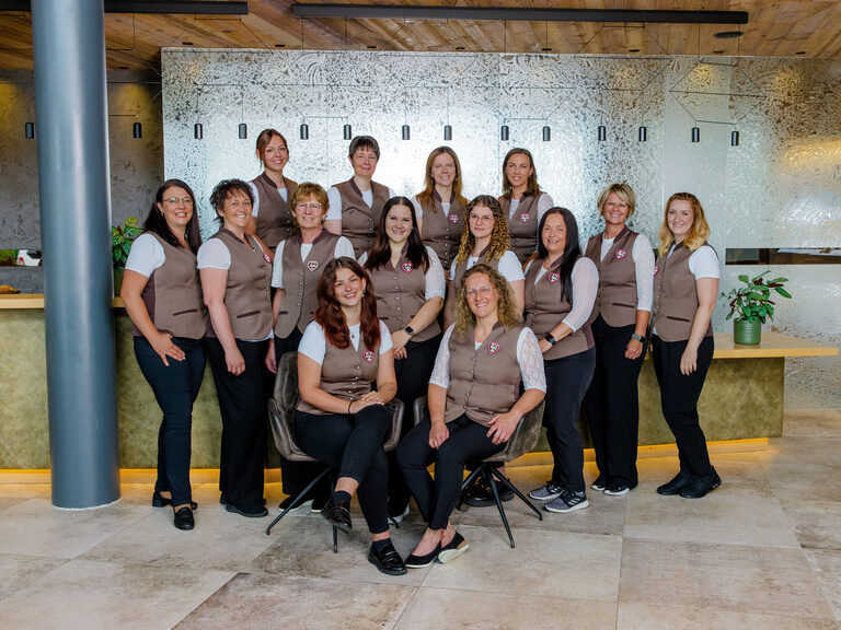 Rezeptionsteam in pinker Trachtenweste im Luxus-Wellnesshotel Hüttenhof